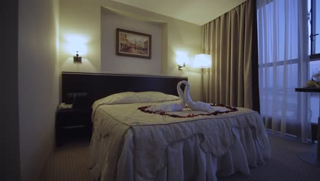 romantic hotel room with swan towels and rose petals