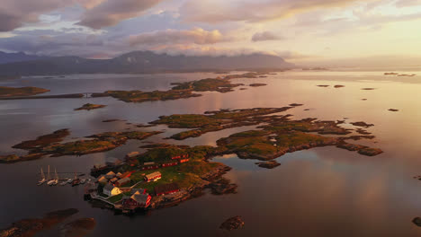 aerial view around a island village towards the atlantic ocean road, sunset in norway - circling, drone shot