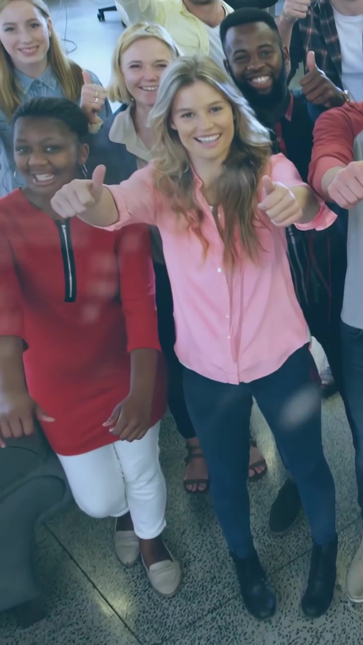 Vertical video: Office team cheering as camera rising and dot code overlay shifting showing thumbs