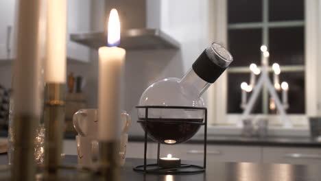 pan of traditional mulled wine bottle and candles on table, christmas