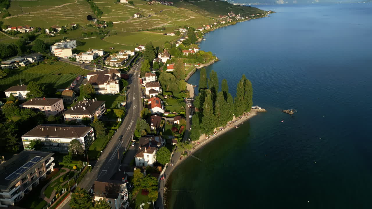 Reveal drone shot of Lavaux terraced vineyards and Lake Geneva during the day near Lutry in canton of Vaud, Switzerland