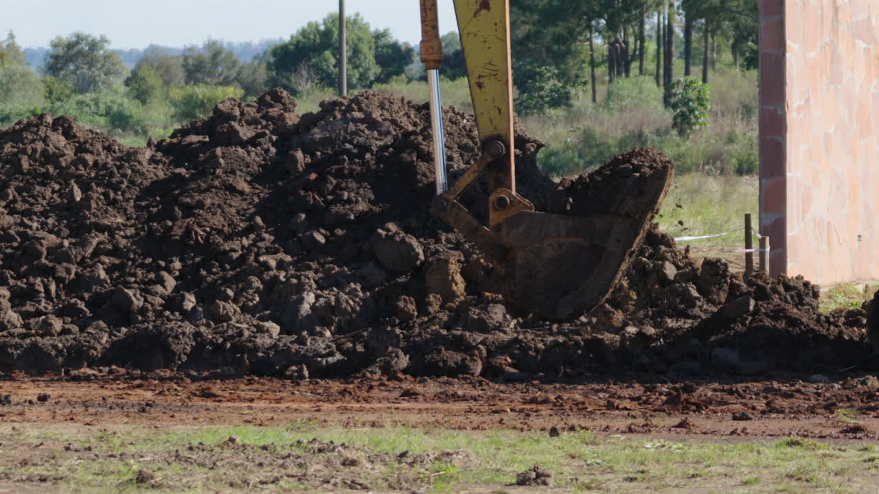 Close-up view of excavator digging soil on a construction site for a land project.