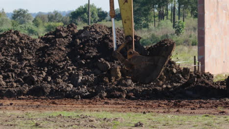 close-up view of excavator digging soil on a construction site for a land project.