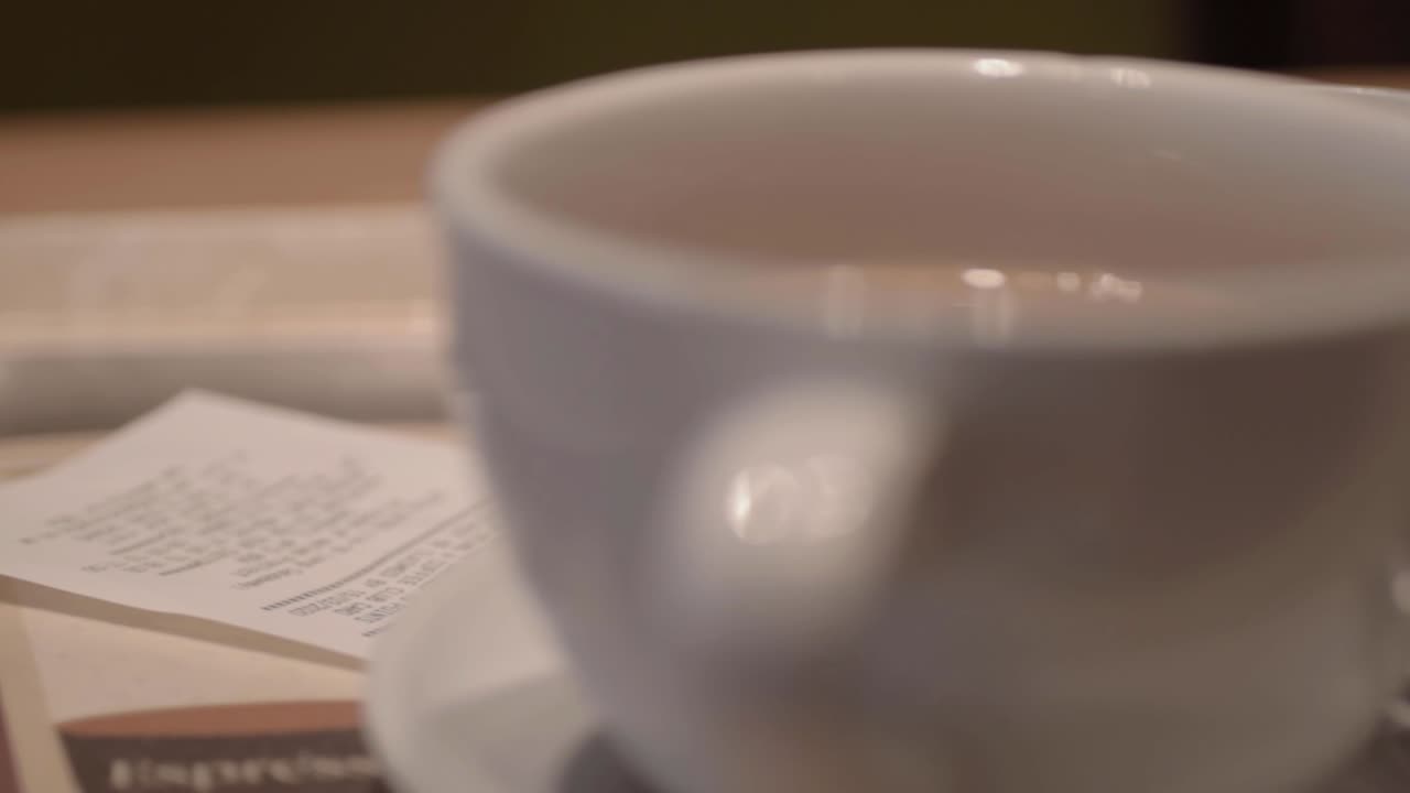 Cup of coffee in cafe with till receipt on table