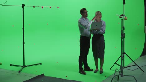 mujeres y hombres colegas con ropa casual hablando, usando computadora portátil en pantalla verde simulacro de chroma key studio. negocios, oficina corporativa, trabajo, concepto de tecnología.