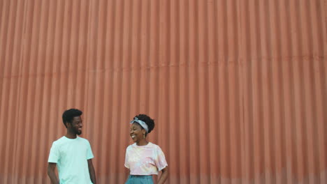 hombre y mujer afroamericanos de pie al aire libre y charlando