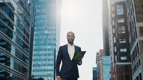 african american businessman using tablet in city financial district