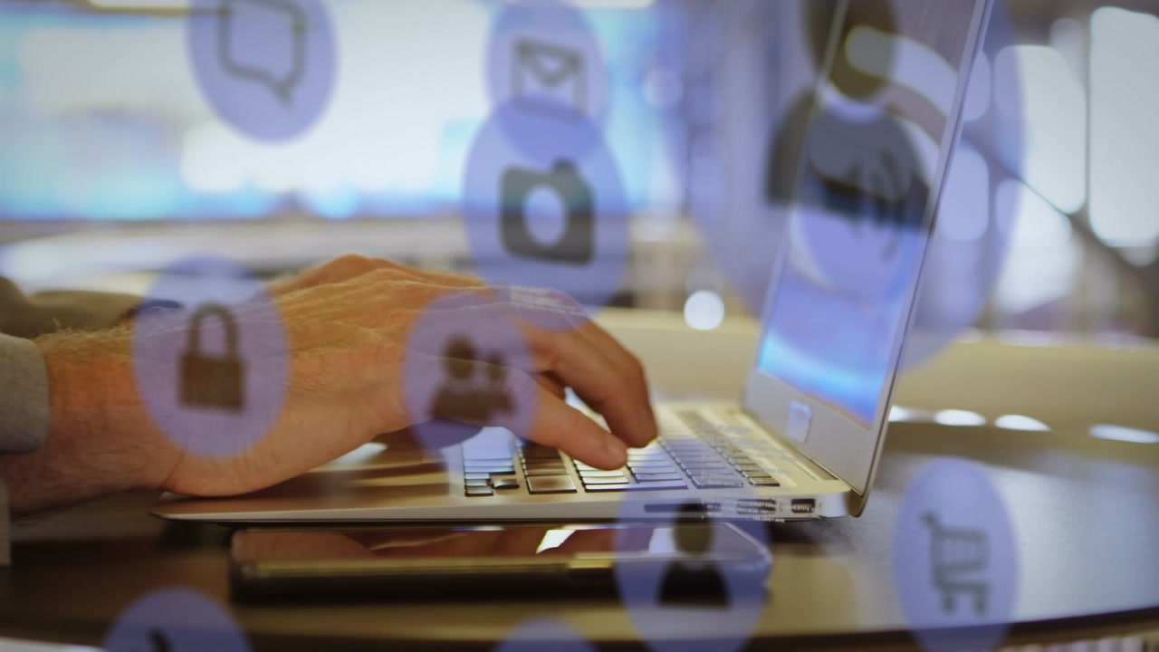 Animation of icons, computer language, cropped hands of caucasian man typing on keyboard of laptop