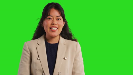 Close-Up-Studio-Portrait-Of-Female-Teacher-Or-Businesswoman-Talking-To-Class-Standing-Against-Green-Screen-Background