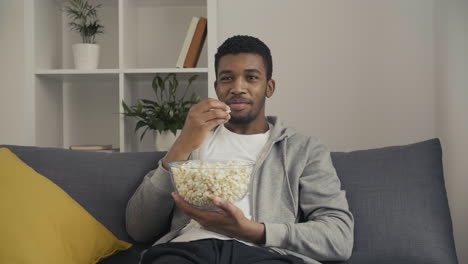 young man enjoying a movie and eating popcorn