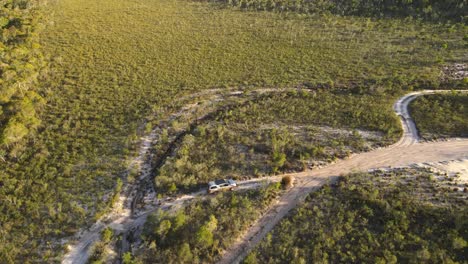 Clip-Aéreo-De-Un-4x4-Conduciendo-Lentamente-En-El-Remoto-Interior-De-Australia,-Al-Final-De-La-Tarde-En-Una-Pista-Forestal,-Clip-Dos