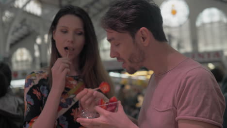 couple enjoying fruit snack in the cups