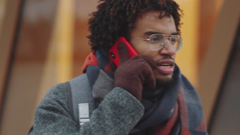 young man on a phone call outdoors in winter