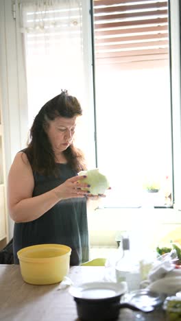 woman preparing cabbage in kitchen