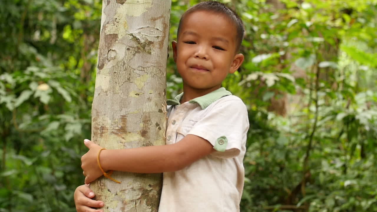Boy Hugging Tree in Forest