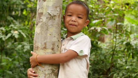 boy hugging tree in forest