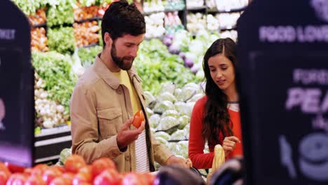 couple selecting vegetables from organic section