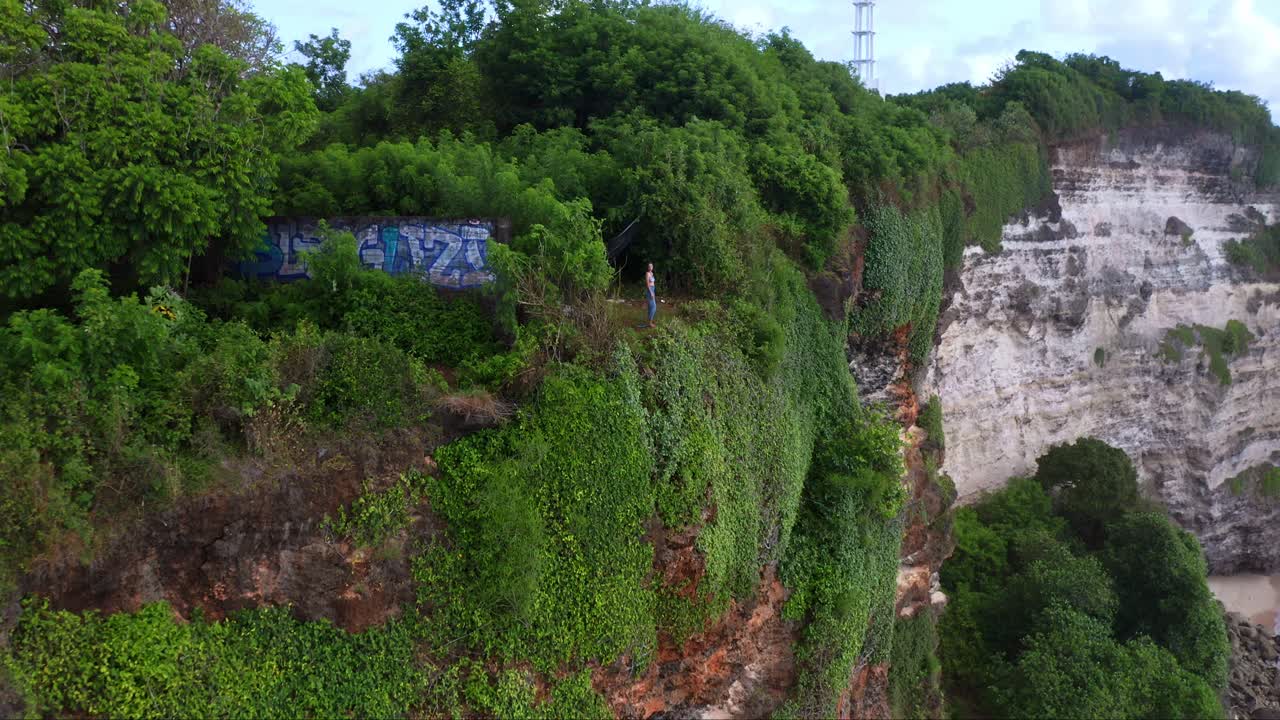 인도네시아 발리 의 부키트 반도 에 있는 울루와투 의 가파른 석회암 절벽 에 서 있는 사람