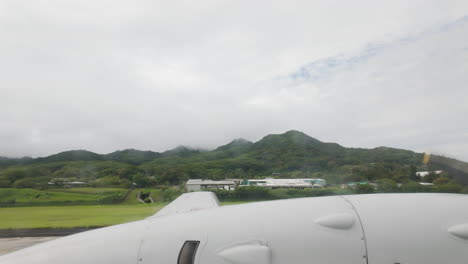 inside airplane looking out at wing and propellor over cook islands rarotonga