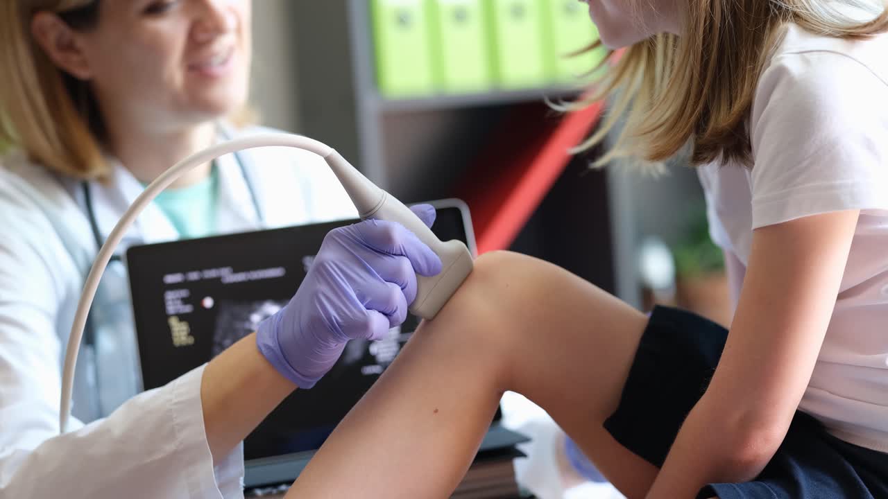 Paziente bambina con medico ortopedico in ambulatorio ed ecografia al ginocchio