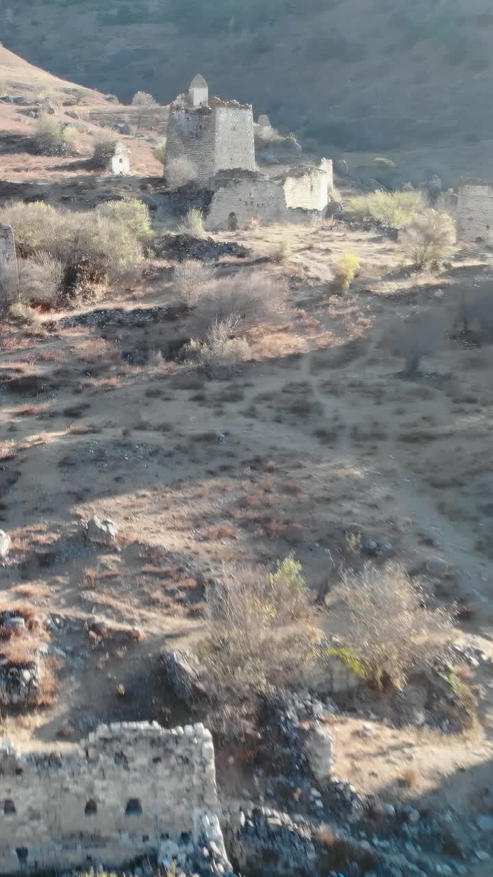 Vista aerea di antiche torri di pietra e rovine su un fianco di montagna