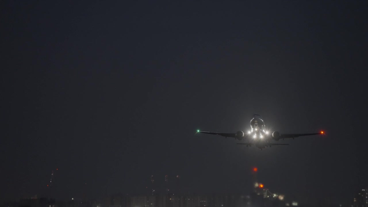 Aereo commerciale in decollo di notte da una pista illuminata