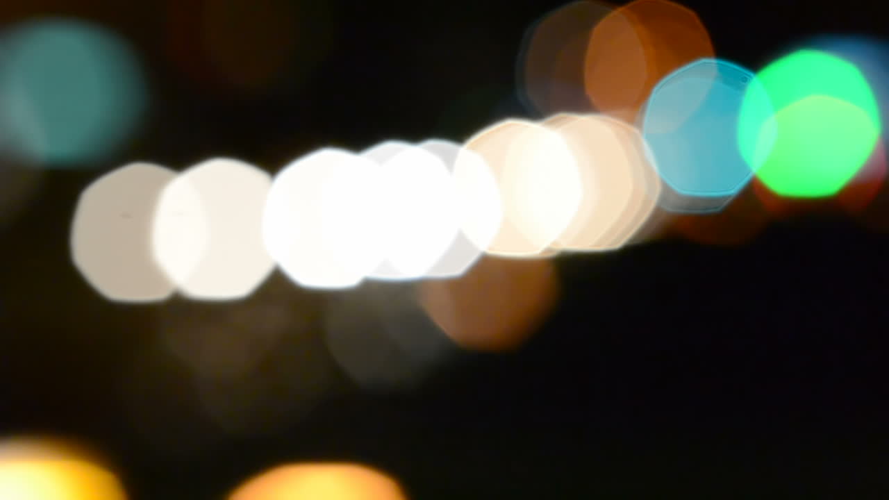 Sfondo notturno illuminato. Luce dai fari in città.