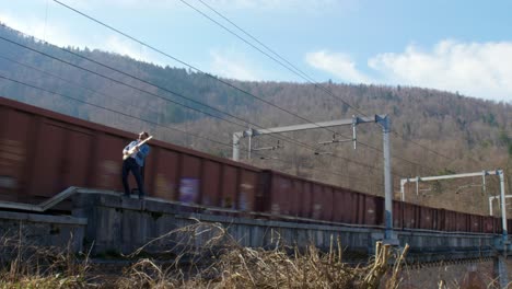 guitarrista en un puente frente a un tren en movimiento