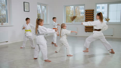 niños en kimono blanco en la clase de artes marciales