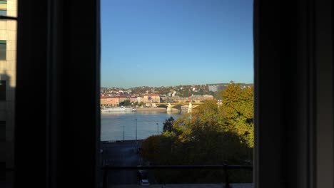street view through windows of an apartment overlooking budapest street, jaszai mari square, hungary