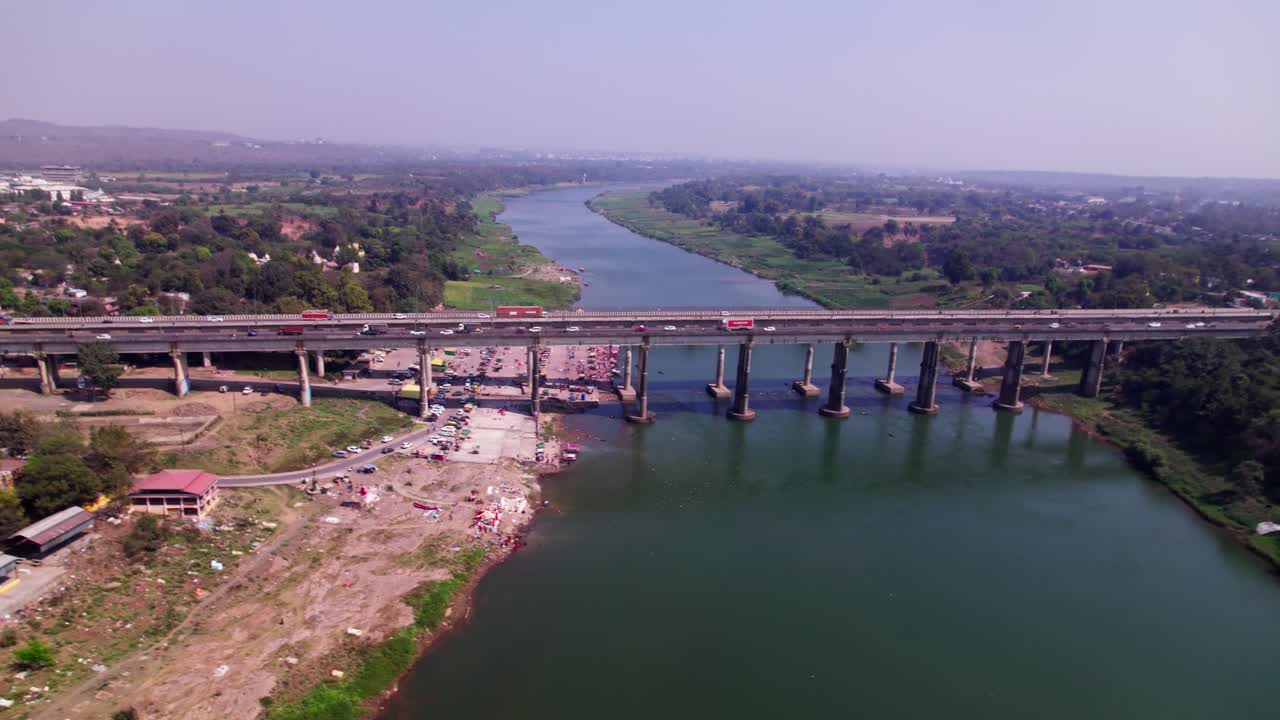 vehicles moving on Tilwara bridge with river and crop fields lands at day time, pan shot, drone shot, 4k.