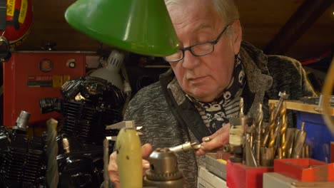 senior mechanic uses vernier caliper to measure metal part in a workshop