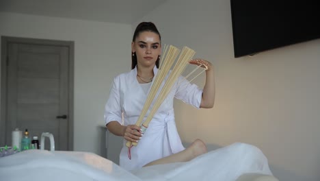Woman giving massage using wooden brush