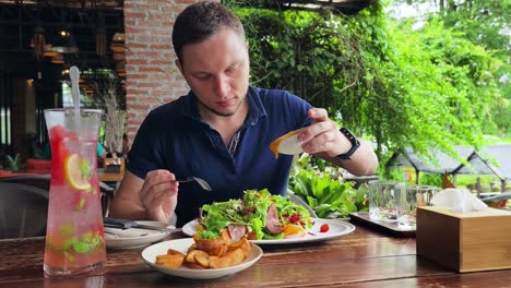 hombre disfrutando de una comida en un café al aire libre