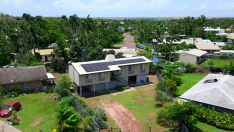 dron aéreo de una casa elevada suburbana promedio con escaleras en el exterior y paneles solares en el techo tropical