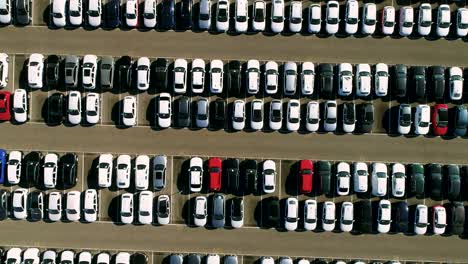 aerial footage of finished cars ready to be shipped on huge distribution center