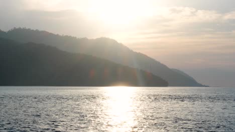 scenic landscape view of remote tropical island with beautiful sunlight reflecting over ocean water in popular vacation destination of raja ampat, west papua, indonesia