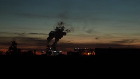 zona industrial con una tubería grande se vierte humo blanco grueso de la tubería de fábrica por la noche