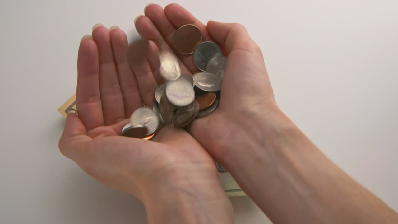 A caucasian woman's hands catches falling American coins
