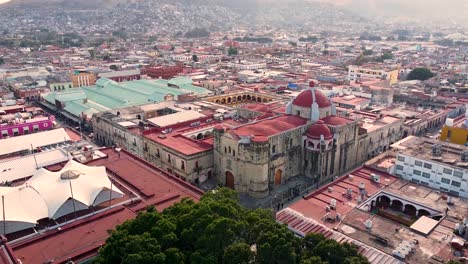 red domed church in the centre of dense city in oaxaca de juarez - mexico