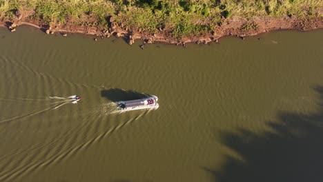 two boats along iguazu river at dusk, border between argentina and brazil