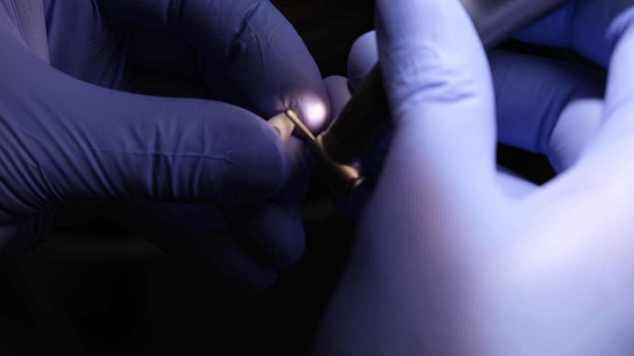 Close-up of hands in medical gloves performing precision work with instruments