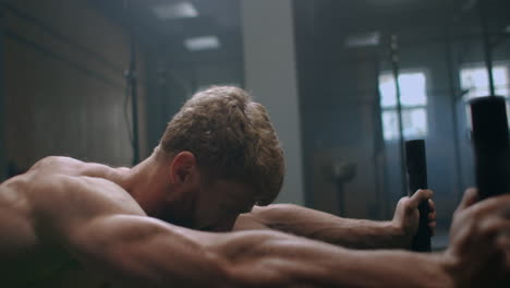 Muscular-man-pushing-sled-at-gym-during-exercise-slow-motion