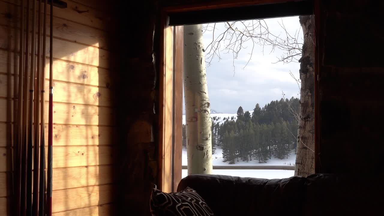 겨울 동안 벽에 걸려 있는 당구 큐로 밖을 봅니다.