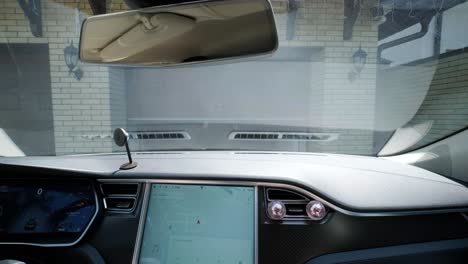 man driver in car thumbed remote control to open the garage door in the house. interior view. pov