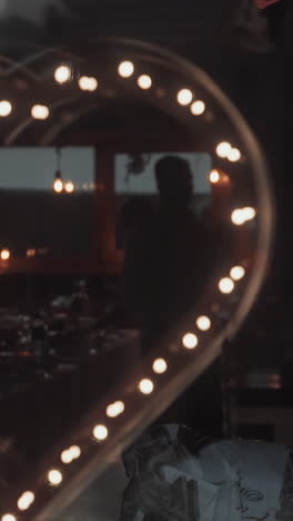 heart made of led lamps and cluster of air balloons in restaurant prepared for wedding celebration party closeup. festive decor for marriage celebration