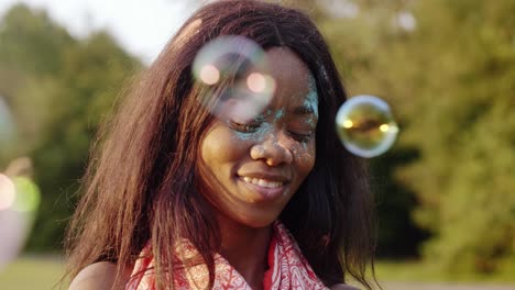 black woman blowing soap bubbles at the summer party