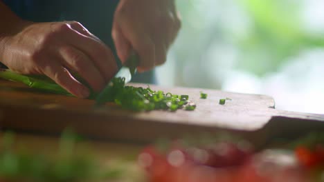 Close-Up-of-Man-Finely-Chopping-Green-Onions-on-Board