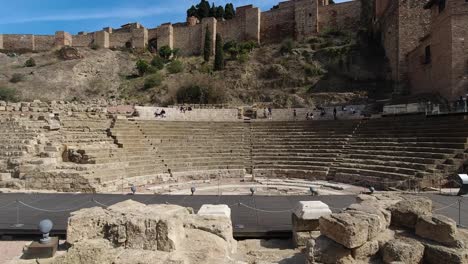 locked off view of famous roman amphitheater in malaga, spain with few people