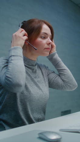 mujer con auriculares en un escritorio de computadora